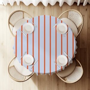 Widok z góry na okrągły stół udekorowany obrusem w pomarańczowe pionowe pasy