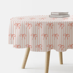 okrągły obrus na stole z pionowymi paskami i powtarzającym się wzorem kokardek