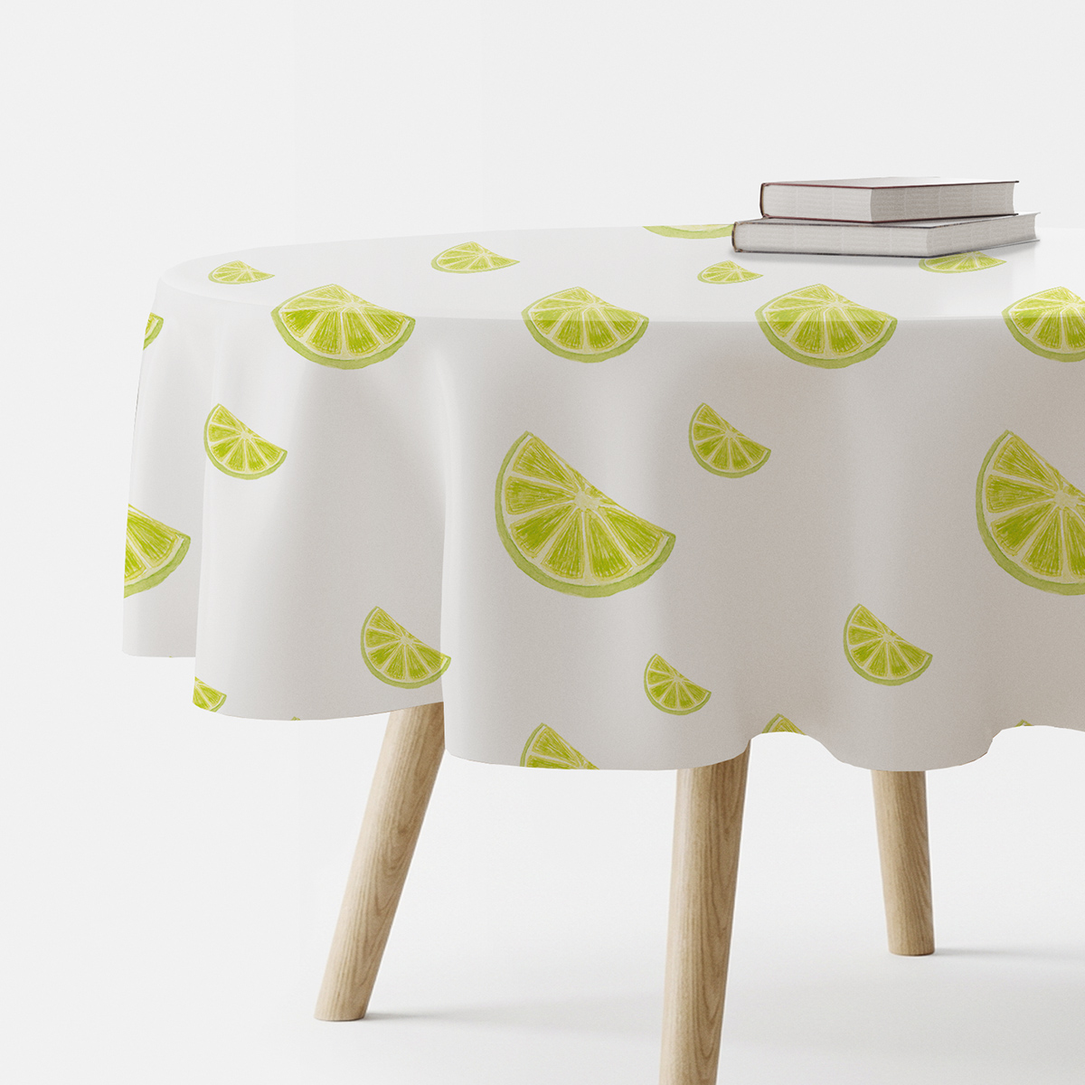okrągły biały obrus z wzorem limonkowych plasterków na drewnianym stole
