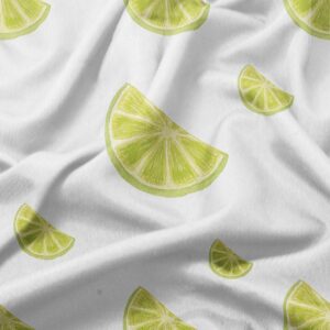 zbliżenie na tkaninę obrusu pokazujące akwarelowe plasterki limonki i fakturę materiału