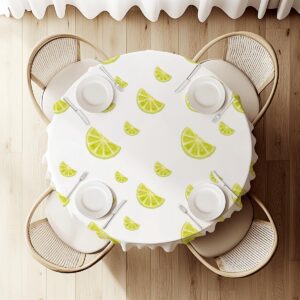 widok z góry na okrągły stół z obrusem w plasterki limonki i nakryciami