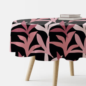 okrągły obrus z malinowymi liśćmi na czarnym tle, widok z boku z książkami na stole