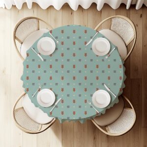 Widok z góry na okrągły stół nakryty miętowym obrusem z powtarzalnym geometrycznym motywem