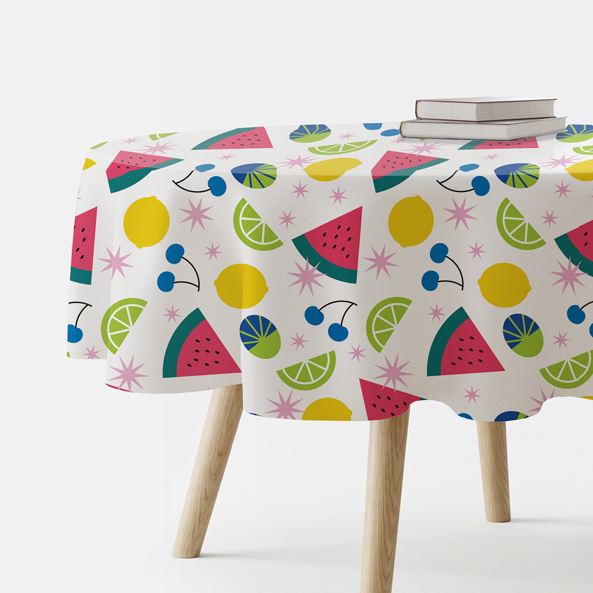 okrągły obrus na stole z kolorowym wzorem owoców i gwiazdek