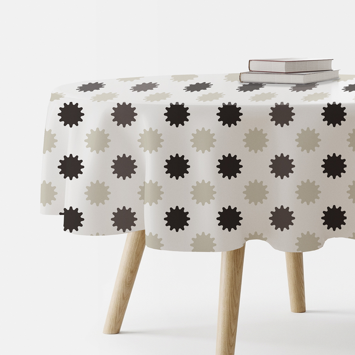 okrągły obrus z neutralnym wzorem rozbłysków ułożony na stoliku z książkami