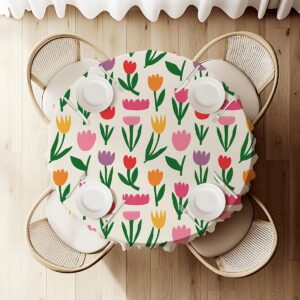 Widok z góry na okrągły obrus z talerzami i rozłożonym wzorem tulipanów