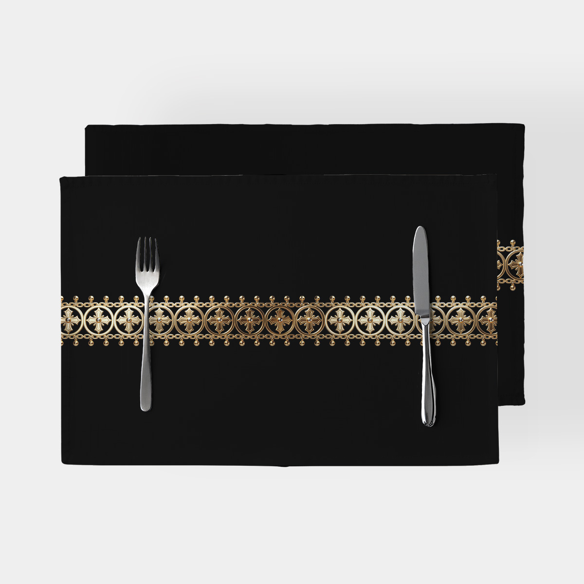 czarne podkładki stołowe z poziomą, barokową złotą bordiurą i sztućcami na wierzchu