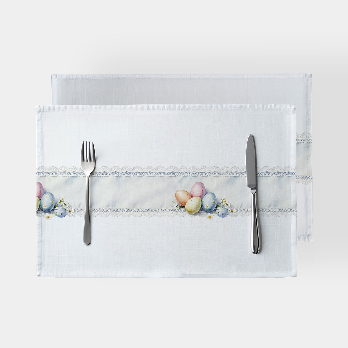 Podkładka stołowa widok z góry z pastelowymi pisankami i koronkowym pasem na białym tle