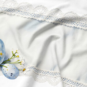 Zbliżenie na koronkowy detal i akwarelowe jajka, widoczna miękka faktura tkaniny