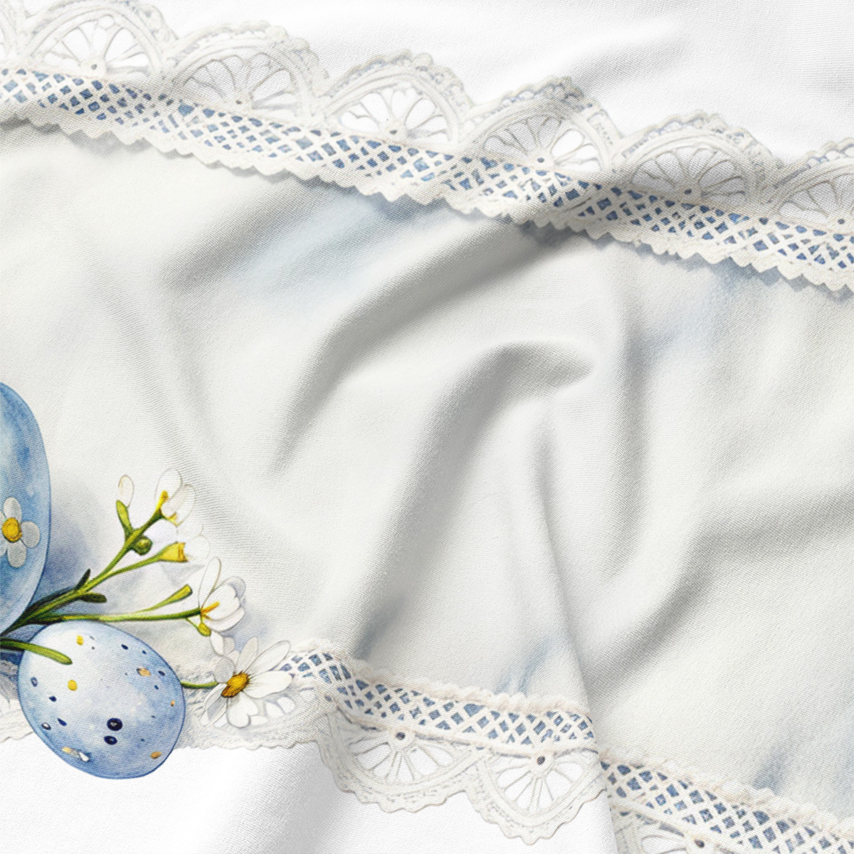 Zbliżenie na koronkowy detal i akwarelowe jajka, widoczna miękka faktura tkaniny