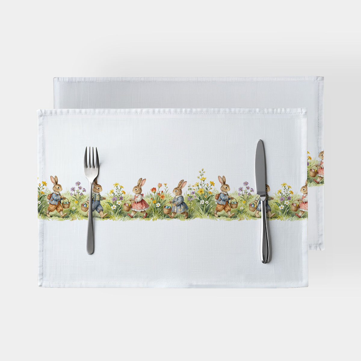 Białe podkładki z paskiem zajączków niosących koszyczki z pisankami na trawie
