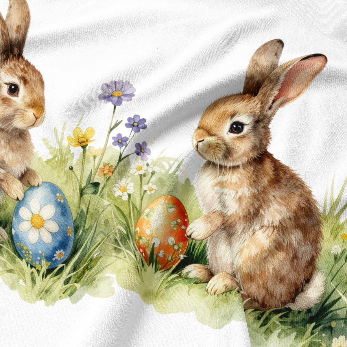 Zbliżenie na nadruk zajączka siedzącego w trawie obok malowanej pisanki, widoczna faktura materiału