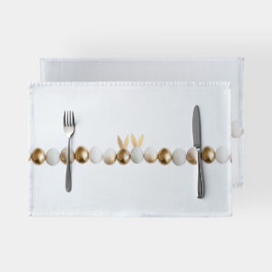 biała podkładka z rzędem złotych i kremowych pisanek, ułożona ze sztućcami po bokach