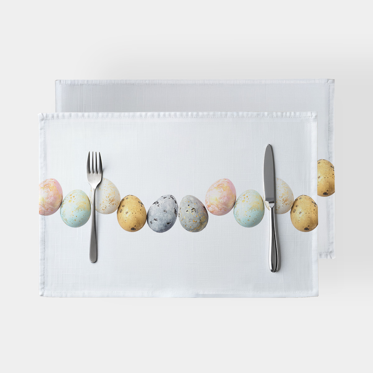 Główne ujęcie podkładki z rzędem pastelowych pisanek i złotymi plamkami na białym tle, widok z góry