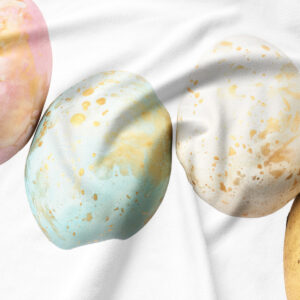 Zbliżenie na nadruk pastelowej pisanki z widocznymi złotymi plamkami i fakturą tkaniny