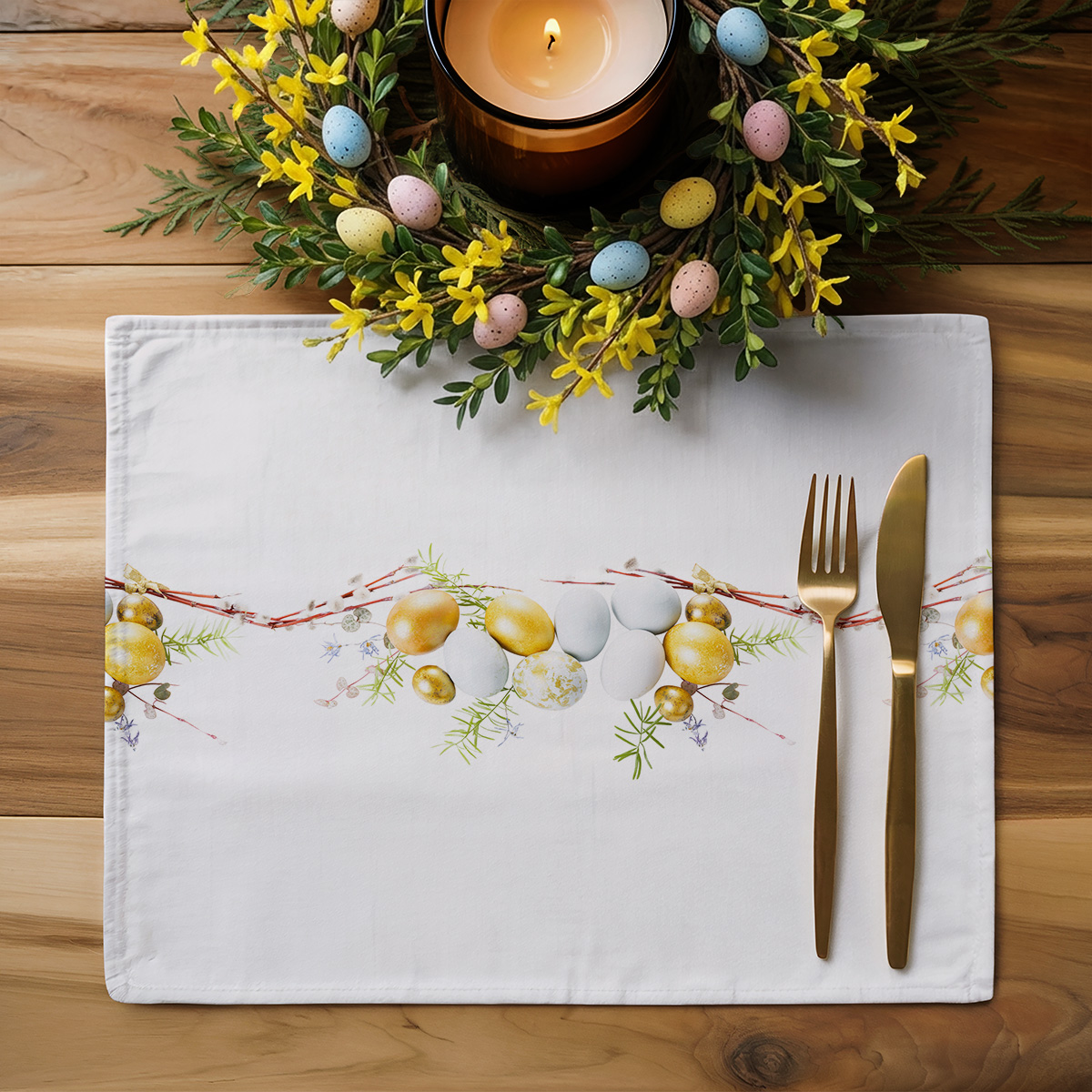 aranżacja stołu z podkładką, złotymi sztućcami i wiosennym wieńcem ze świecą i ozdobnymi jajkami