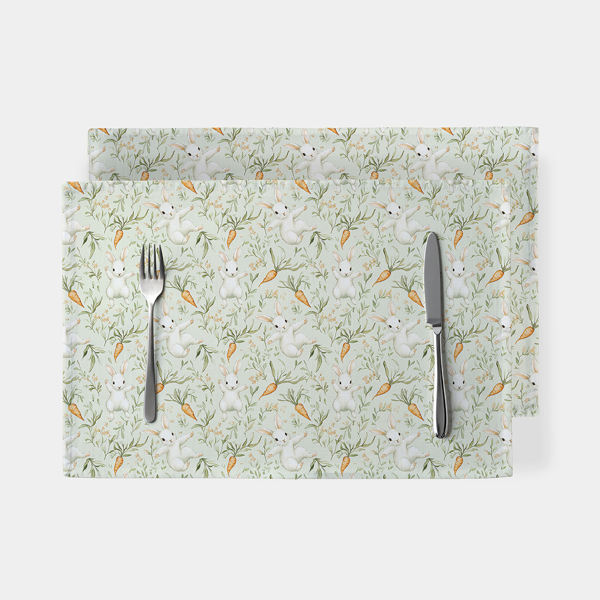 Podkładki stołowe z akwarelowym wzorem białych zajączków i marchewek na miętowym tle, widok z góry