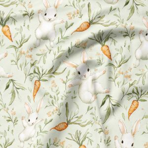 Zbliżenie detalu tkaniny z akwarelowymi zajączkami, marchewkami i delikatnymi gałązkami