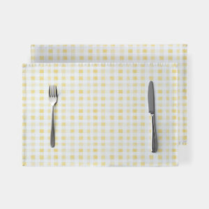 Widok z góry na pojedynczą podkładkę w żółtą kratkę z widocznymi sztućcami