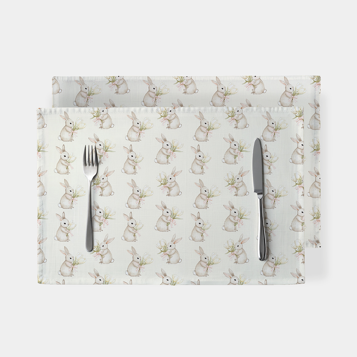 Główne ujęcie podkładki z motywem zajączków trzymających bukiety tulipanów ustawione na stole