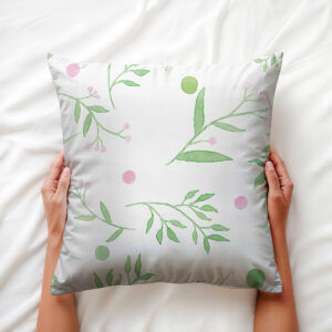 dłoń trzymająca poduszkę z motywem gałązek i różowych kropek, widok z góry
