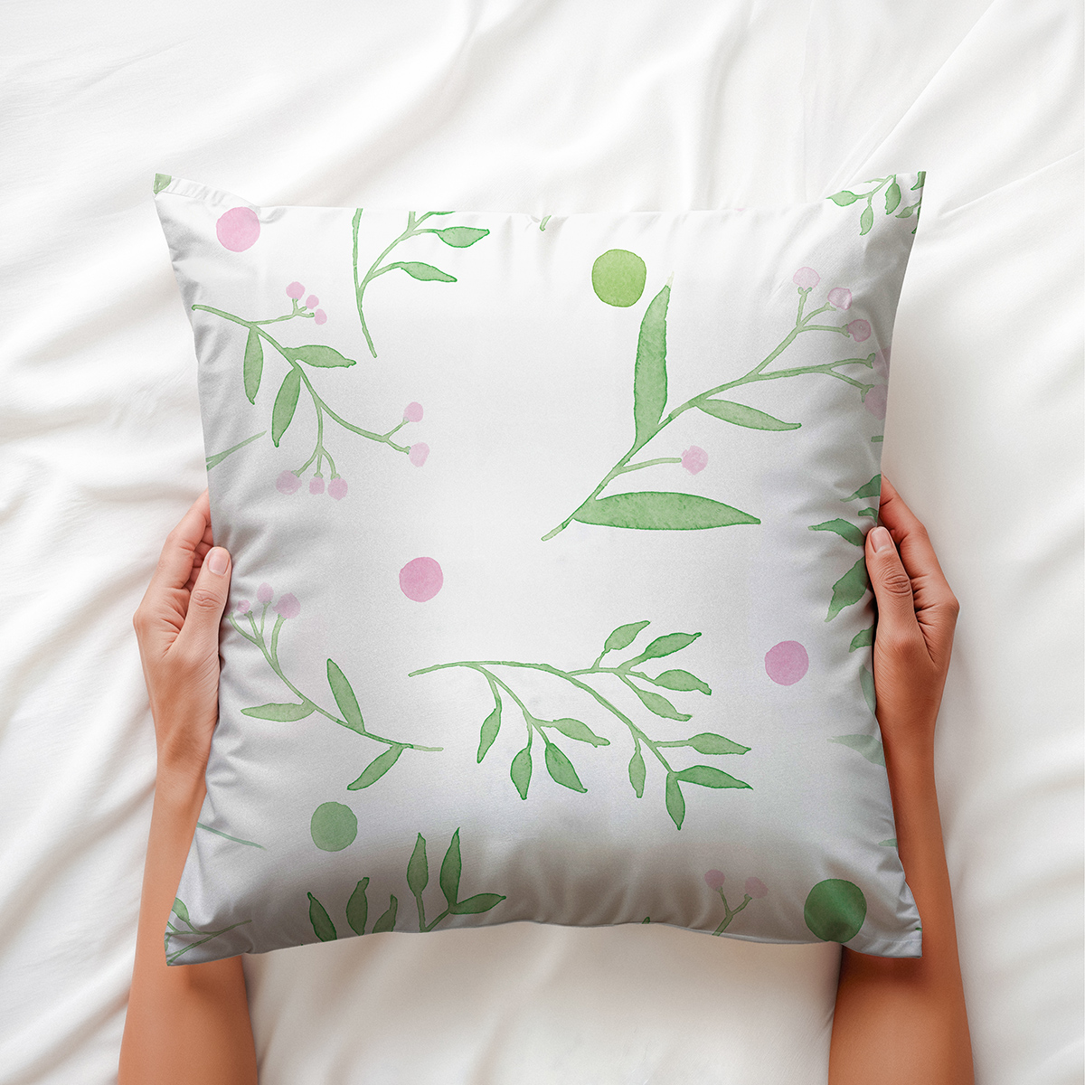 dłoń trzymająca poduszkę z motywem gałązek i różowych kropek, widok z góry