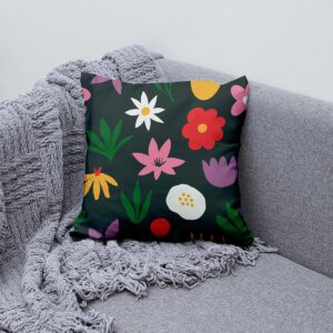 poduszka z kwiatowym wzorem ustawiona na kanapie obok szarego koca