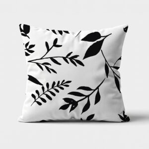 Główne ujęcie poduszki z czarno-białym wzorem gałązek i liści na jasnym tle
