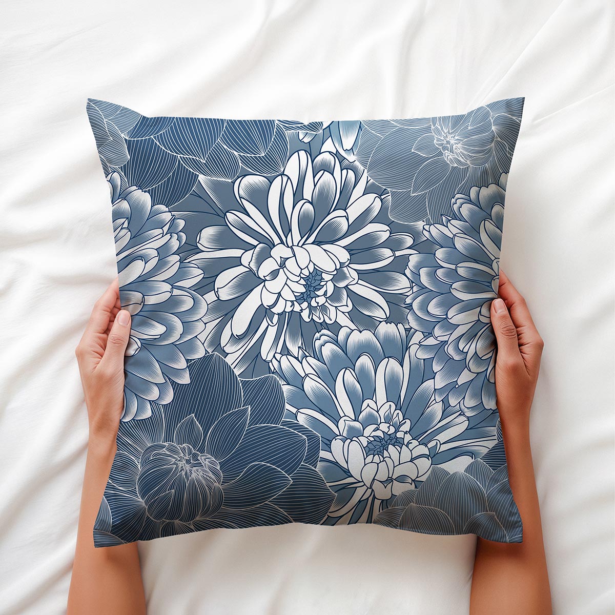 Widok z góry na poduszkę trzymaną w dłoniach, detal nadruku chryzantem i faktury materiału