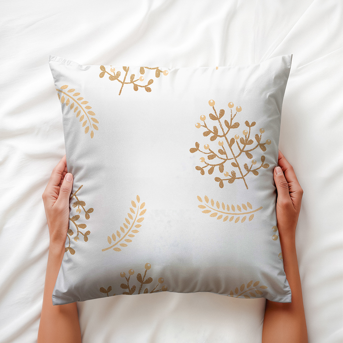 Dłoń trzymająca poduszkę z dekoracyjnym motywem złotych listków — ujęcie aranżacyjne