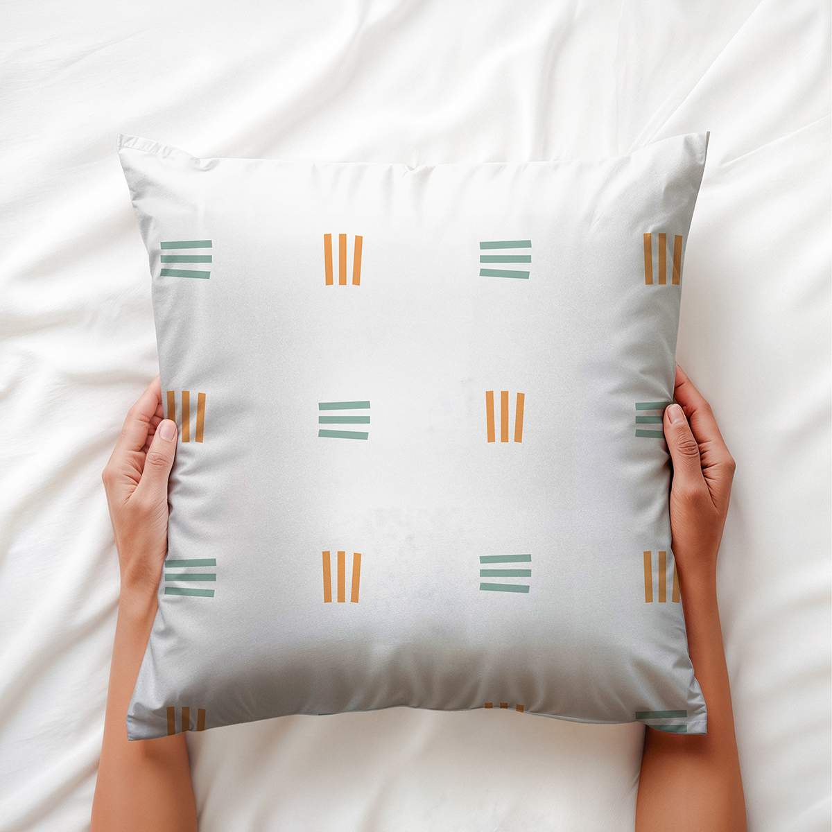ręce trzymające poduszkę z bliska, widoczny motyw równoległych kresek i gładka tkanina
