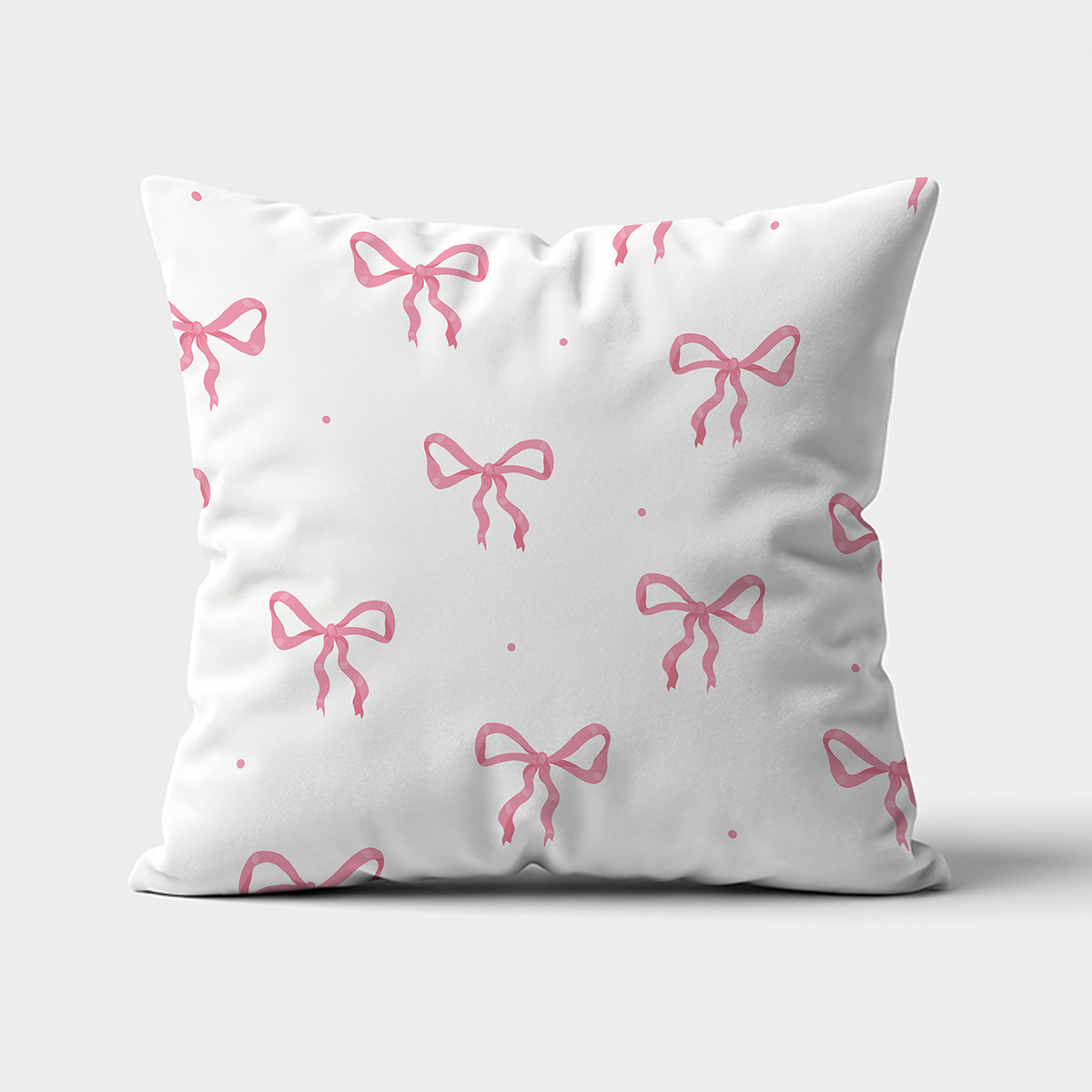 Główne ujęcie białej poduszki z powtarzalnymi różowymi kokardkami na jasnym tle
