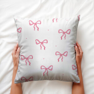 Poduszka dekoracyjna trzymana w dłoniach, widoczne detale wzoru kokard