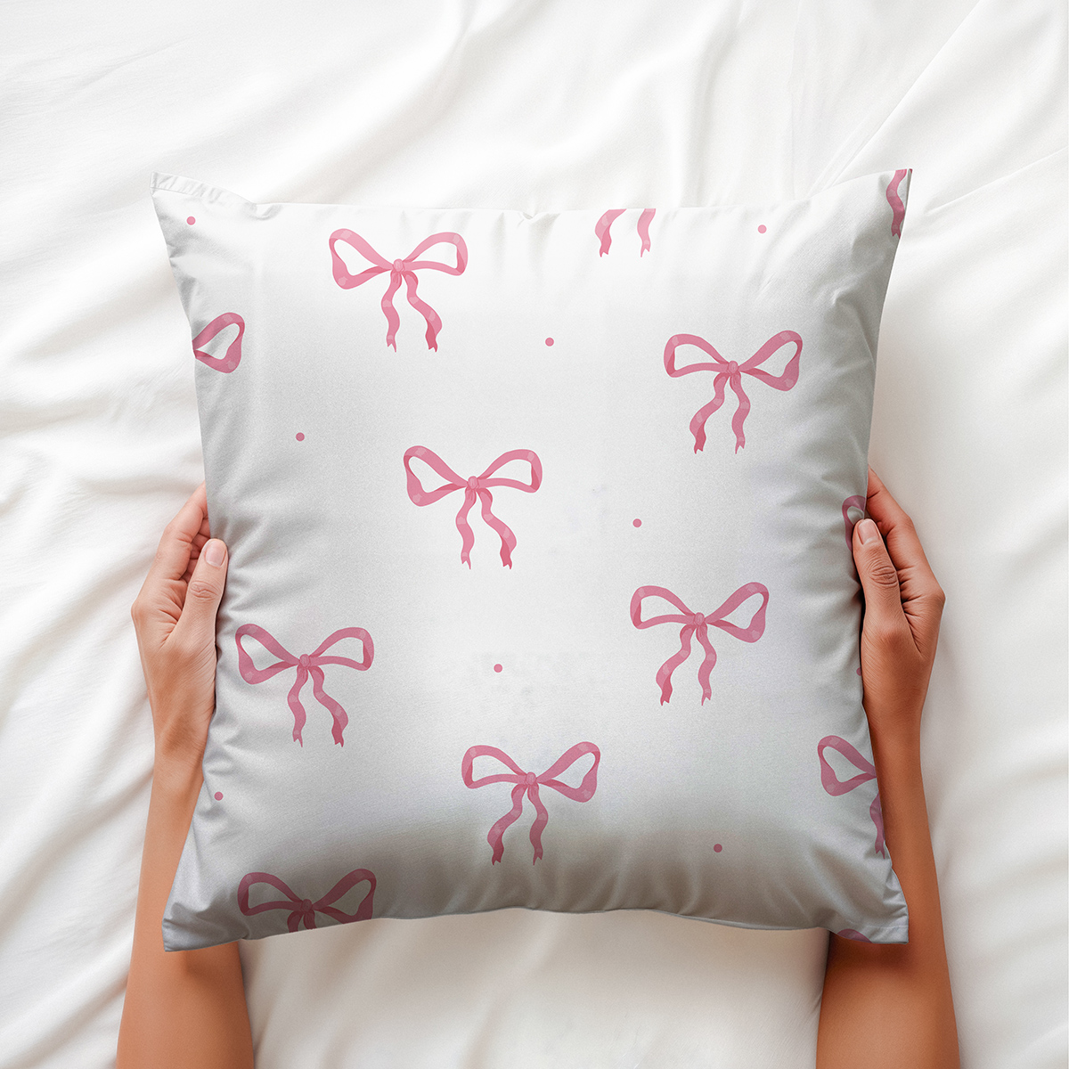 Poduszka dekoracyjna trzymana w dłoniach, widoczne detale wzoru kokard