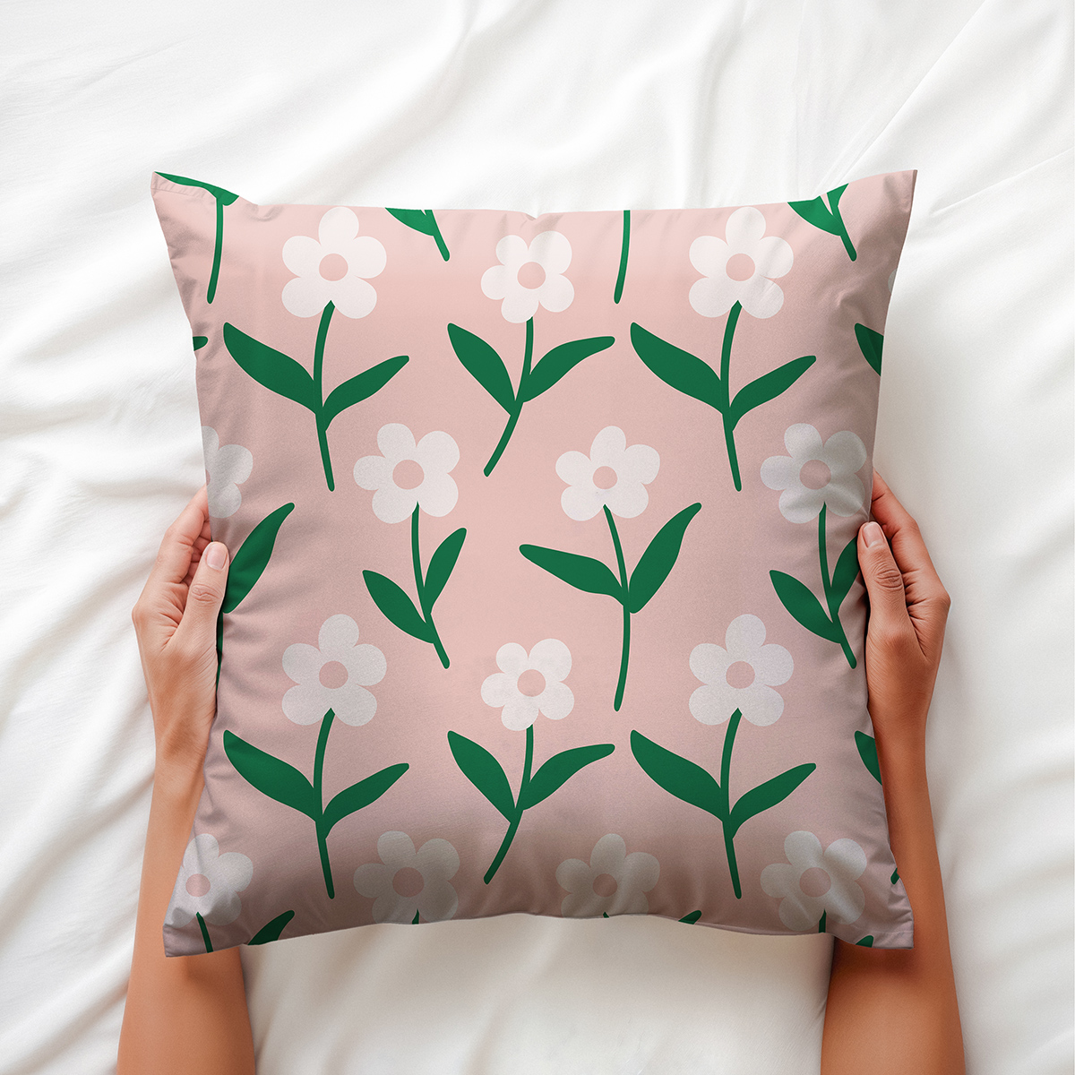 Poduszka dekoracyjna trzymana w dłoniach, widok z przodu ukazujący rozmieszczenie stokrotek