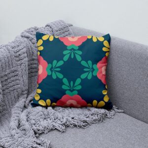 Poduszka z motywem koralowych kwiatów ustawiona na szarej sofie jako kolorowy akcent wnętrza