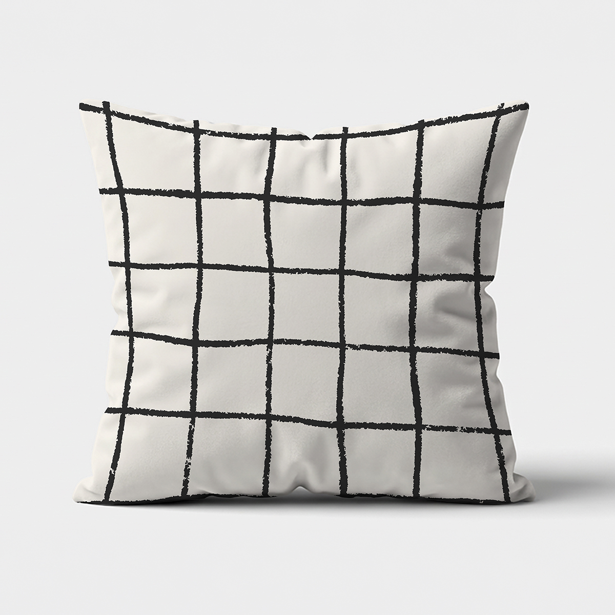Frontowe ujęcie poduszki dekoracyjnej z czarną kratą malowaną pędzlem na jasnym tle