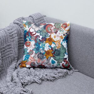 Poduszka z kwiatowym motywem ułożona na kanapie obok szarego koca, aranżacja wnętrza