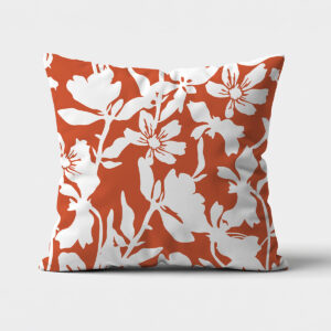 Główne ujęcie poduszki z białym, kwiatowym wzorem na ceglastym tle