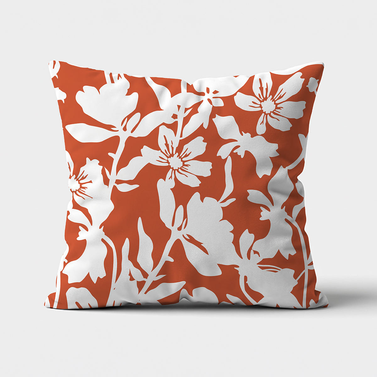 Główne ujęcie poduszki z białym, kwiatowym wzorem na ceglastym tle