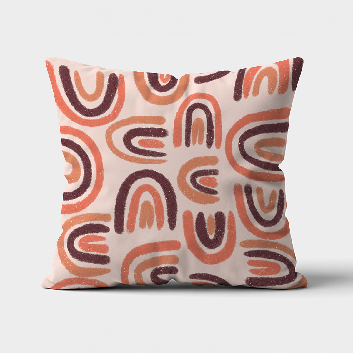 Główne ujęcie poduszki z wzorem łuków w ciepłych, ziemistych odcieniach na jasnym tle