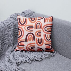 Aranżacja: poduszka z łukami ustawiona na szarej sofie obok teksturowanego koca