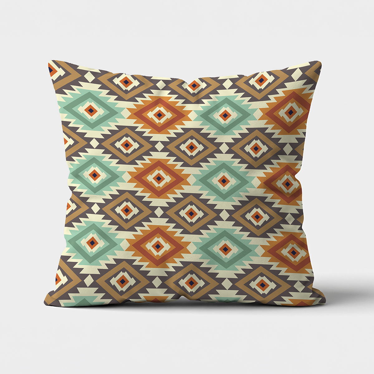 Główne ujęcie poduszki z azteckim wzorem w miętowo-terakotowych barwach na jasnym tle