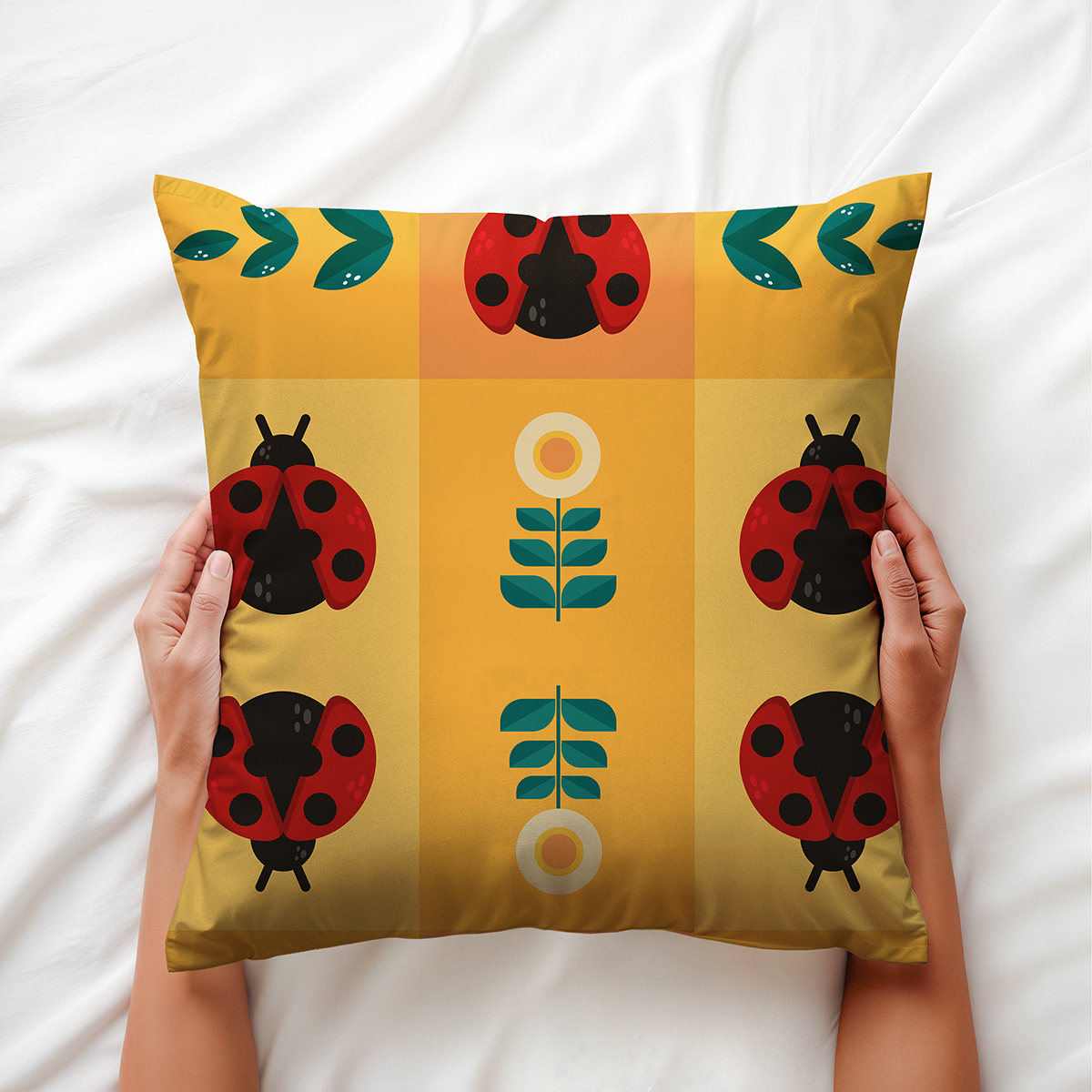 Osoba trzymająca poduszkę z motywem biedronek i stylizowanych kwiatów, ujęcie z bliska