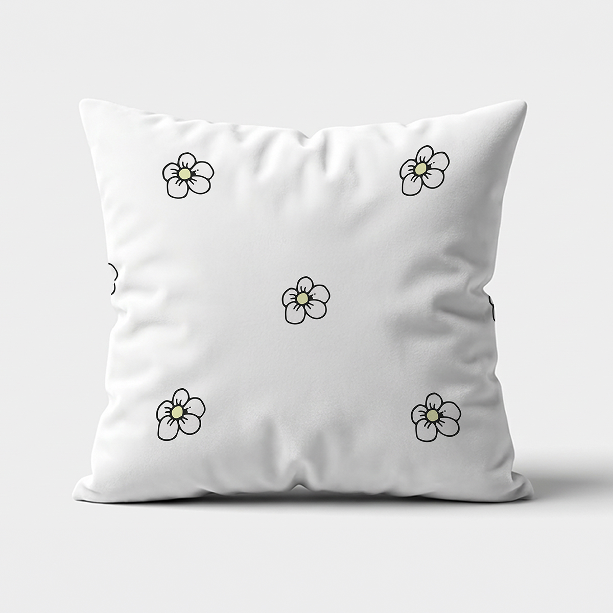 Widok z przodu poduszki z rozproszonym wzorem drobnych stokrotek na jasnym tle