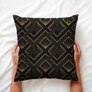 Poduszka z motywem art deco trzymana w dłoniach na jasnej pościeli, detal wzoru