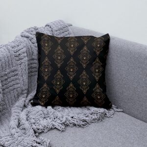 Poduszka z wzorem art deco na szarej sofie obok pledu, detal ornamentów