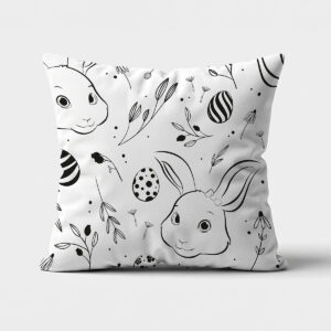 poduszka z czarno-białym wzorem króliczków i pisanek, widok z przodu na jasnym tle