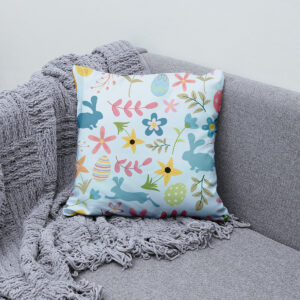 Poduszka ułożona na szarej sofie obok pledu, aranżacja wiosennego wnętrza