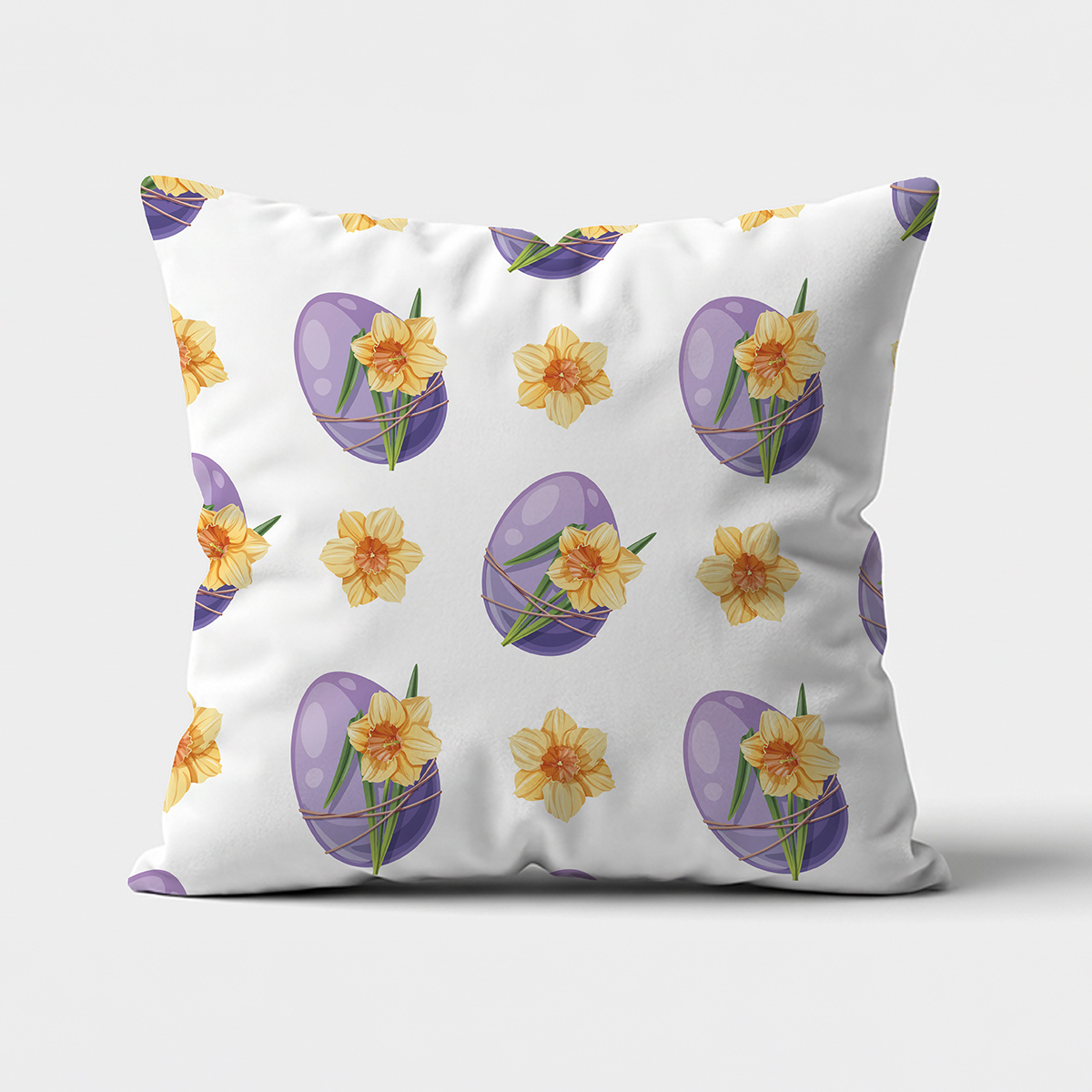 Poduszka na białym tle z fioletowymi pisankami i żonkilami